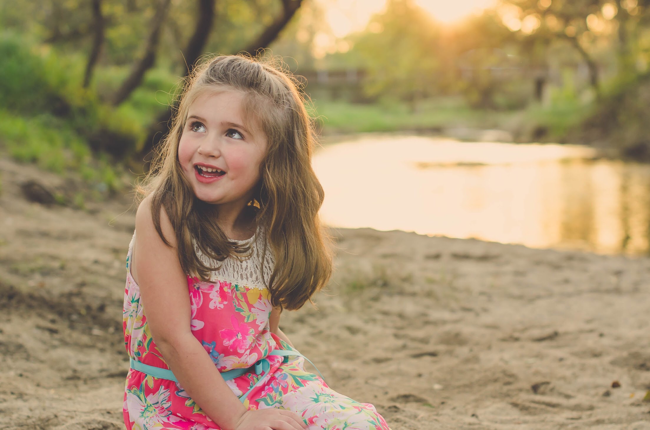 Taylor smiling beside the water in warm evening light